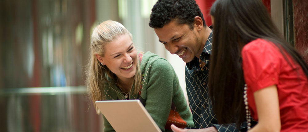 Students laughing and working together on campus